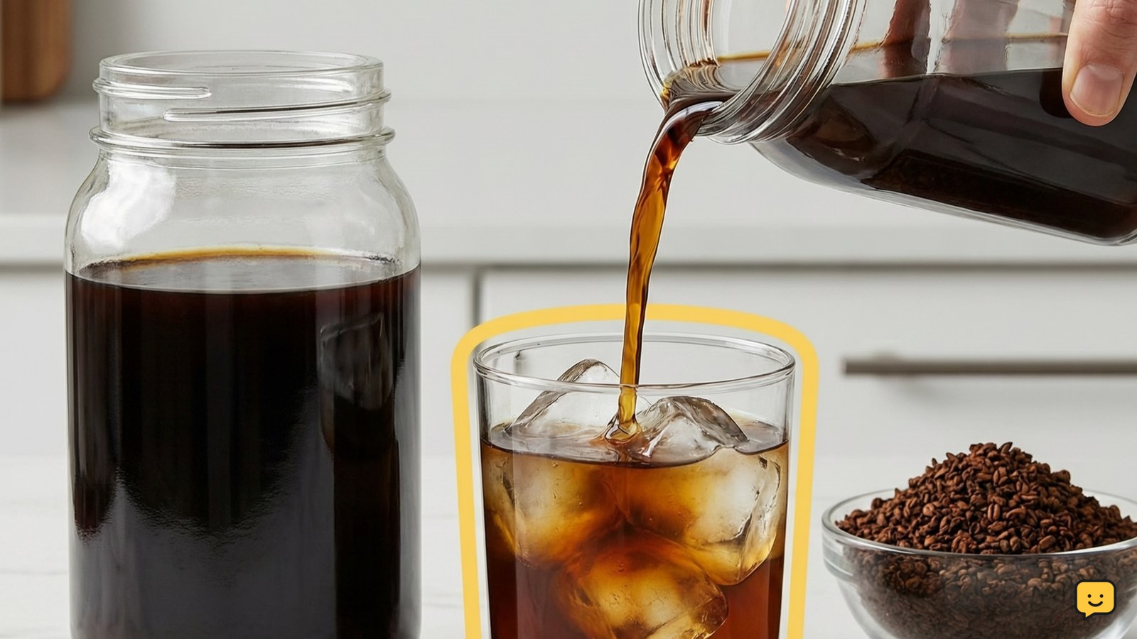 Dark cold brew concentrate poured into a glass over ice beside a sealed storage jar and coarse coffee grounds