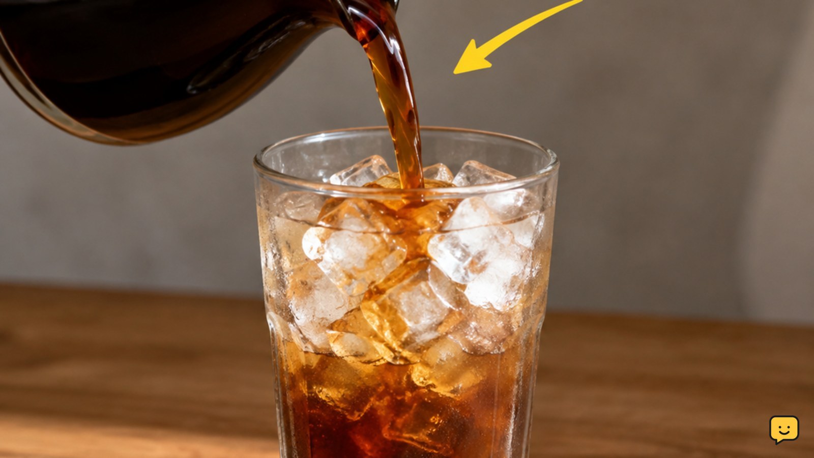 Freshly brewed coffee being poured over a full glass of ice