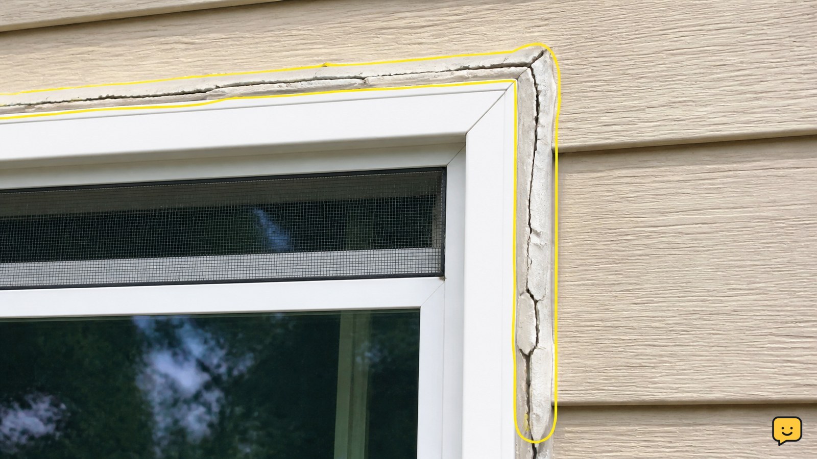 Cracked and peeling exterior sealant along the edge of a residential window frame