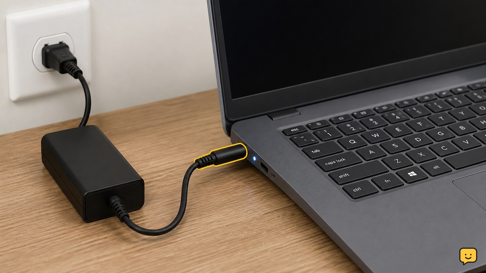 Dell laptop connected to an AC adapter with its charging light visible