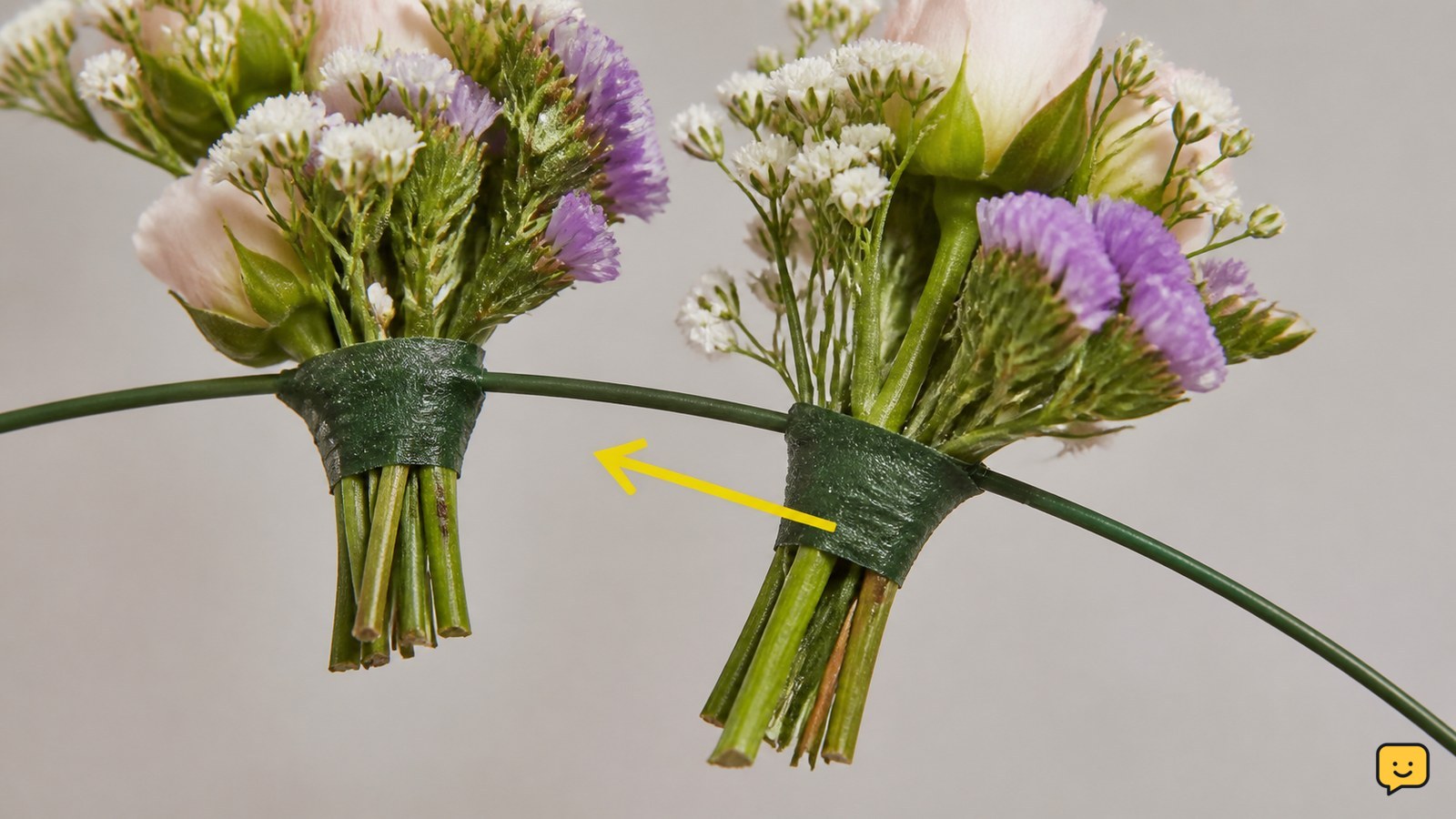 Close-up of a taped flower bundle being attached to a curved floral wire crown base, with the next bundle overlapping the stems